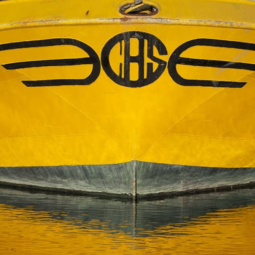 Coque de bateau jaune se reflétant dans l'eau