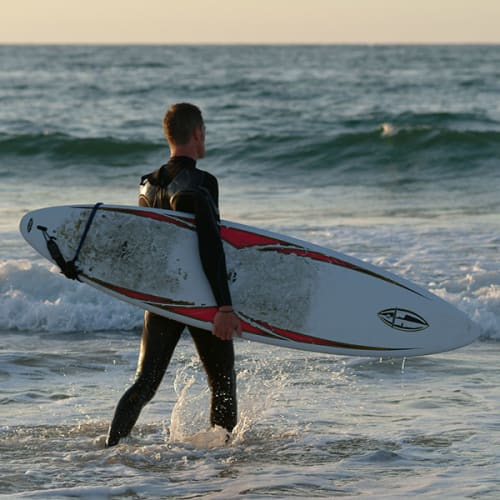 Surfeur entrant dans l'eau